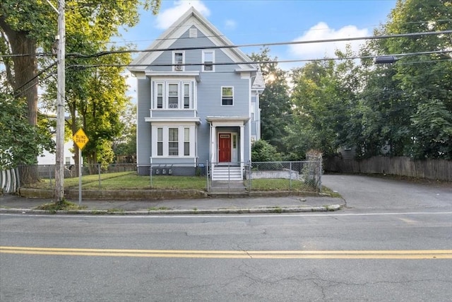 view of front facade with aphalt driveway and a fenced front yard