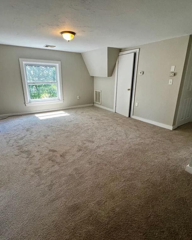 additional living space featuring visible vents, carpet flooring, and baseboards