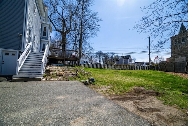 view of yard featuring a wooden deck, stairway, and fence