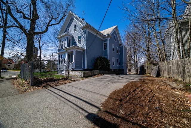 view of side of home featuring fence and driveway