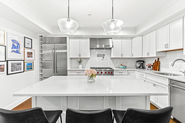 280 W 5th St Unit 101, Boston, MA 02127 - kitchen with wall chimney range hood, appliances with stainless steel finishes, decorative backsplash, crown molding, and white cabinets
