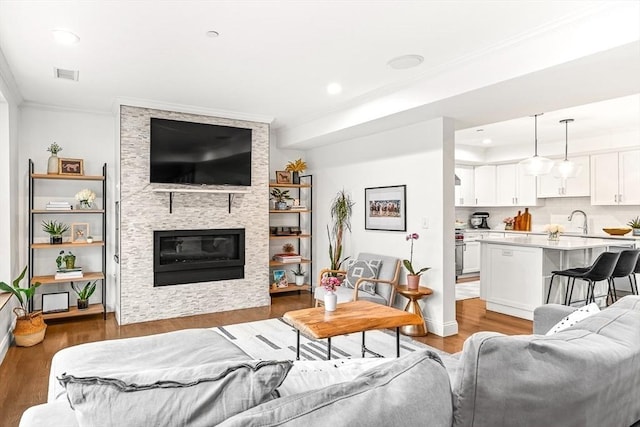 280 W 5th St Unit 101, Boston, MA 02127 - living area featuring crown molding, light wood-style flooring, a large fireplace, and recessed lighting