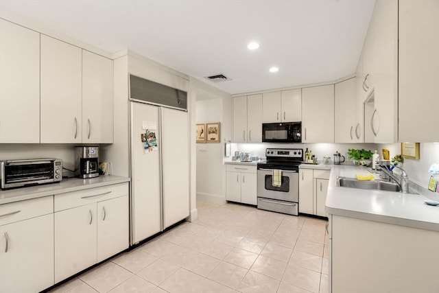 228 Allandale Rd Unit 1A, Boston, MA 02467 - kitchen featuring stainless steel electric stove, black microwave, paneled refrigerator, a sink, and light countertops