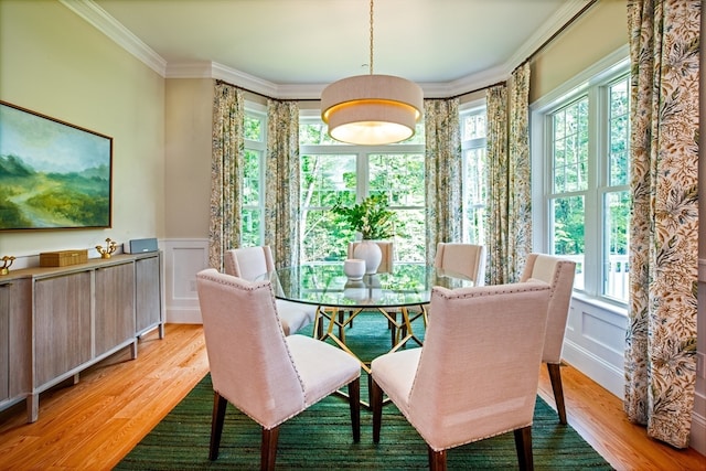 dining area with light wood-type flooring, plenty of natural light, and crown molding