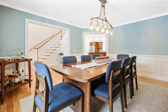 dining area with ornamental molding and wood-type flooring