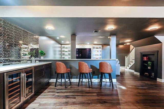 bar featuring dark hardwood / wood-style floors, built in features, and beverage cooler