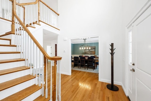 entryway featuring ornamental molding, a towering ceiling, and hardwood / wood-style floors