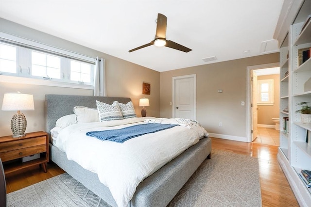 bedroom featuring ensuite bath, ceiling fan, and light hardwood / wood-style floors