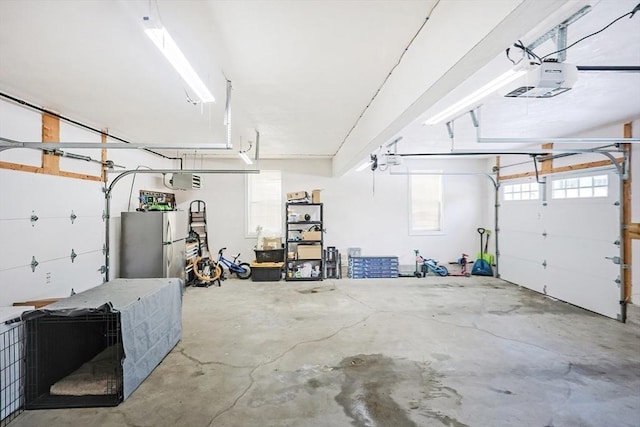 garage with stainless steel refrigerator and a garage door opener