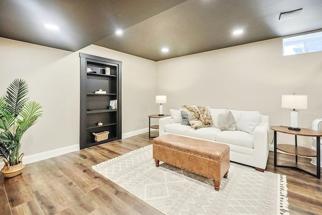 living room with hardwood / wood-style floors and built in features