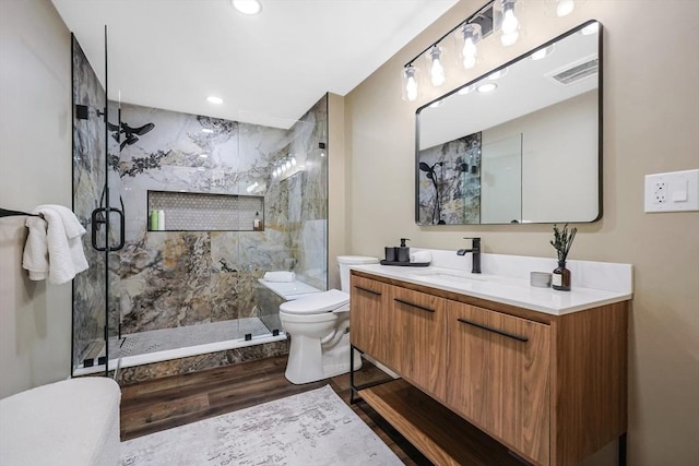 bathroom featuring vanity, an enclosed shower, hardwood / wood-style floors, and toilet