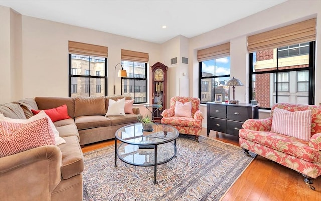 living area featuring recessed lighting, hardwood / wood-style floors, and visible vents
