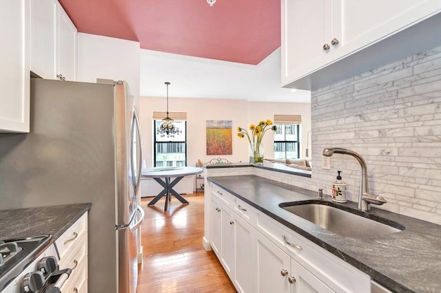 kitchen with light wood-style floors, a sink, white cabinetry, and a wealth of natural light