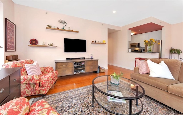 living room featuring recessed lighting, baseboards, and wood finished floors