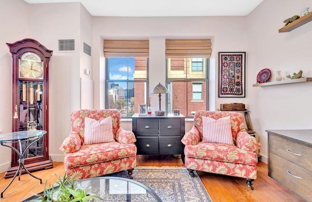living area featuring plenty of natural light, wood finished floors, and visible vents