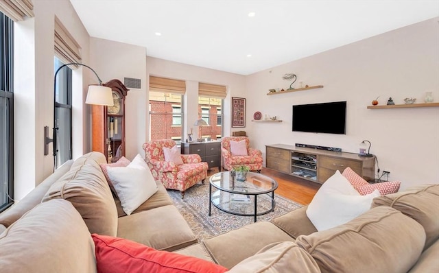 living area featuring recessed lighting, visible vents, and wood finished floors