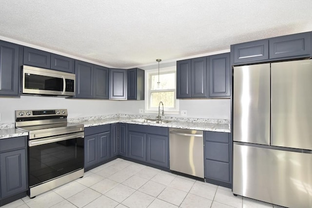 kitchen with light tile patterned flooring, a textured ceiling, appliances with stainless steel finishes, and a sink