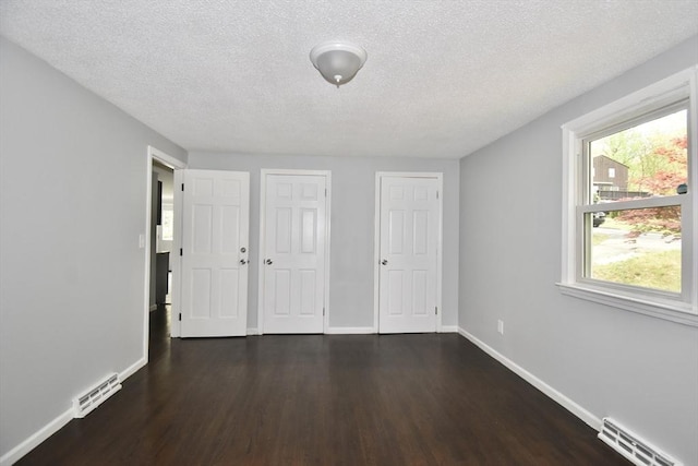 interior space featuring visible vents, dark wood finished floors, and baseboards