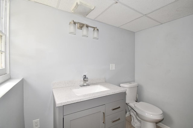 bathroom featuring toilet, visible vents, a paneled ceiling, and vanity