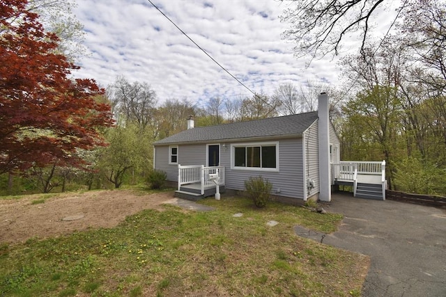 bungalow-style house with a chimney and a wooden deck