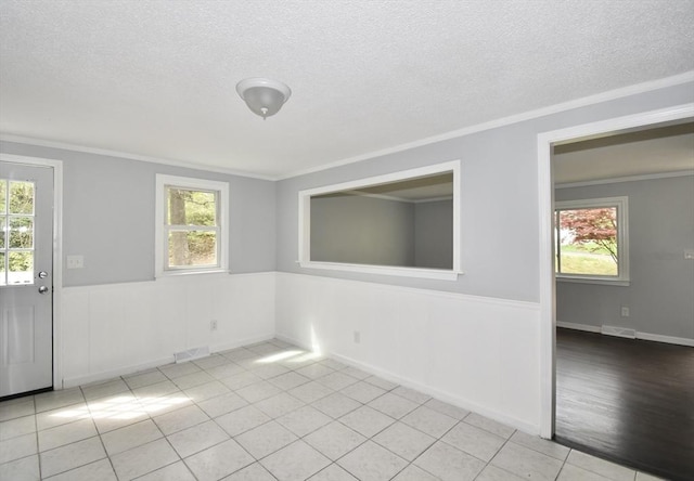 unfurnished room featuring a textured ceiling and a wealth of natural light
