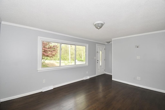 unfurnished living room featuring a textured ceiling, visible vents, wood finished floors, baseboards, and ornamental molding