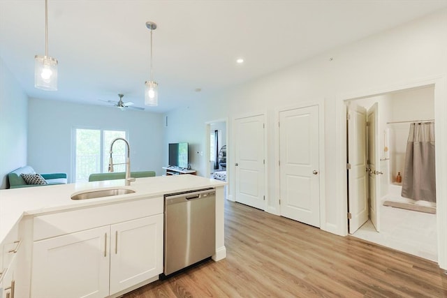 kitchen with stainless steel dishwasher, a sink, decorative light fixtures, light wood-type flooring, and ceiling fan