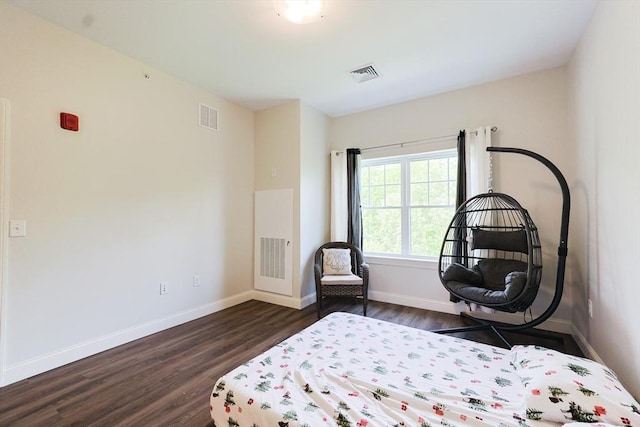 bedroom with dark wood finished floors and baseboards