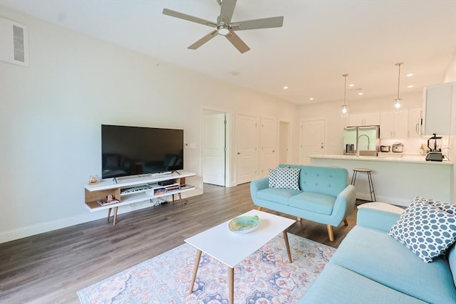 living room with wood finished floors, ceiling fan, baseboards, and recessed lighting