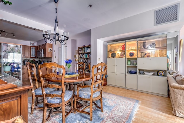 dining room with a notable chandelier and light wood-type flooring