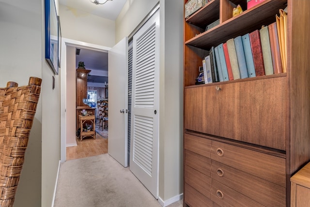 corridor featuring light colored carpet