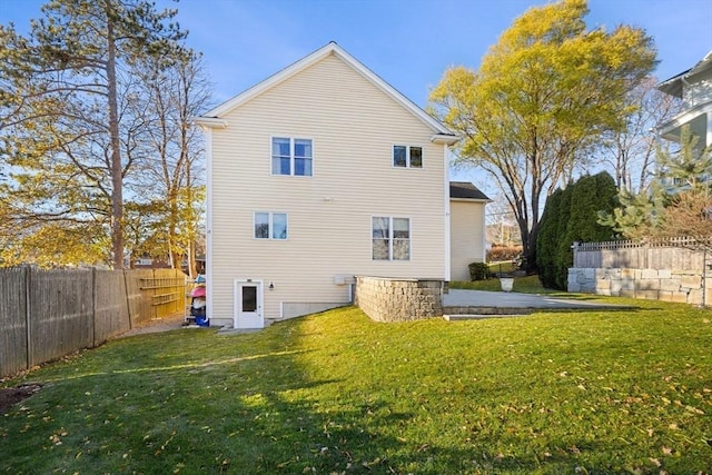 rear view of house featuring a lawn