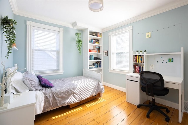 bedroom with baseboards, light wood-style flooring, and ornamental molding