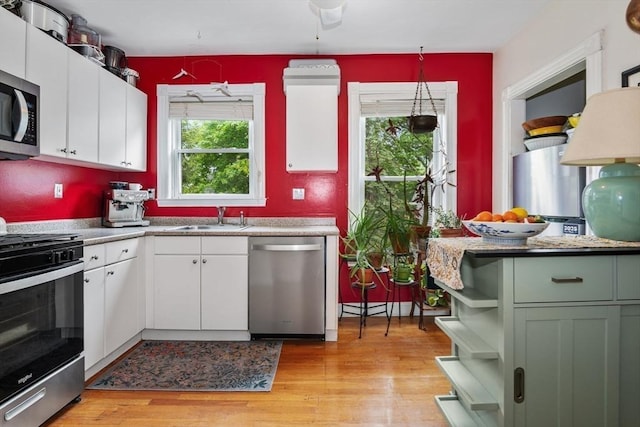 4 Marlou Unit 3, Boston, MA 02130 - kitchen featuring appliances with stainless steel finishes, a sink, light wood-type flooring, white cabinets, and open shelves