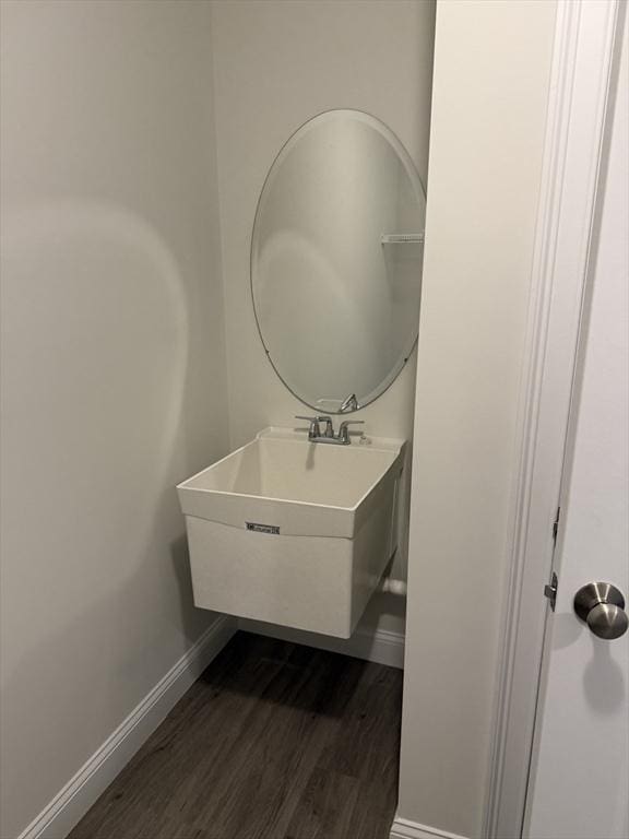 bathroom with a sink, wood finished floors, and baseboards