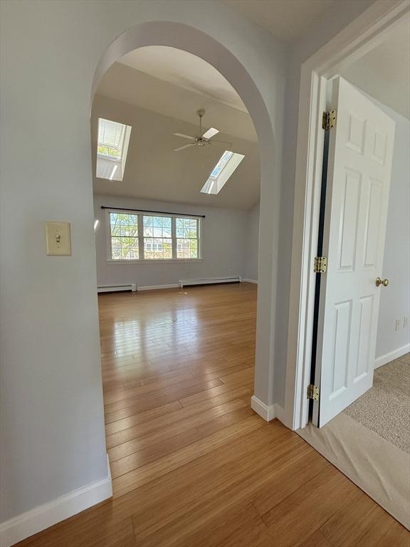 56 Center St Unit 2-3, Dennis, MA 02639 - unfurnished room featuring arched walkways, baseboards, a skylight, and vaulted ceiling