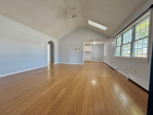 56 Center St Unit 2-3, Dennis, MA 02639 - unfurnished living room featuring baseboard heating, a ceiling fan, a skylight, vaulted ceiling, and light wood-style floors