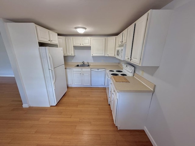 56 Center St Unit 2-3, Dennis, MA 02639 - kitchen with white appliances, a sink, light countertops, light wood-style floors, and white cabinets