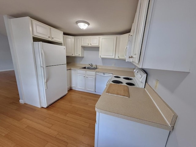 56 Center St Unit 2-3, Dennis, MA 02639 - kitchen with white appliances, light wood-style floors, a sink, white cabinets, and light countertops