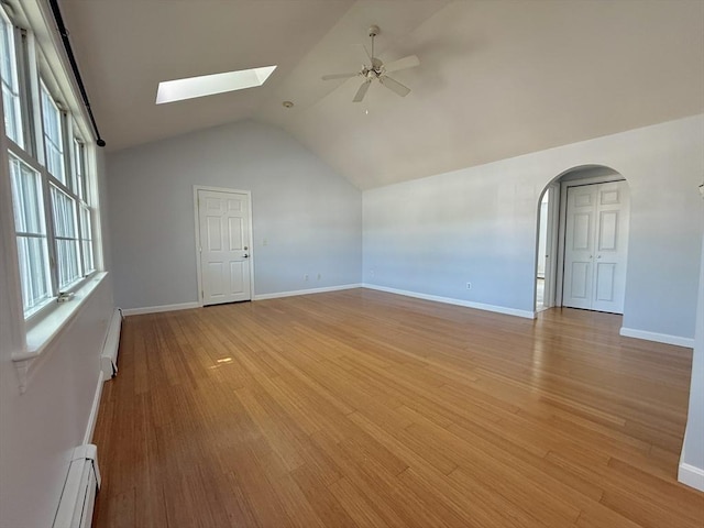 56 Center St Unit 2-3, Dennis, MA 02639 - spare room with baseboard heating, ceiling fan, a skylight, lofted ceiling, and light wood-style floors