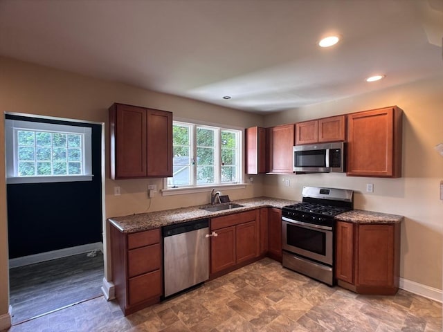 29 Neptune Ave, West Springfield, MA 01089 - kitchen featuring stainless steel appliances, a sink, brown cabinets, stone counters, and baseboards