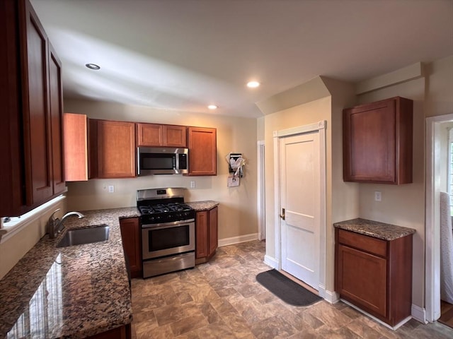 29 Neptune Ave, West Springfield, MA 01089 - kitchen featuring stainless steel appliances, a sink, dark stone countertops, baseboards, and brown cabinetry