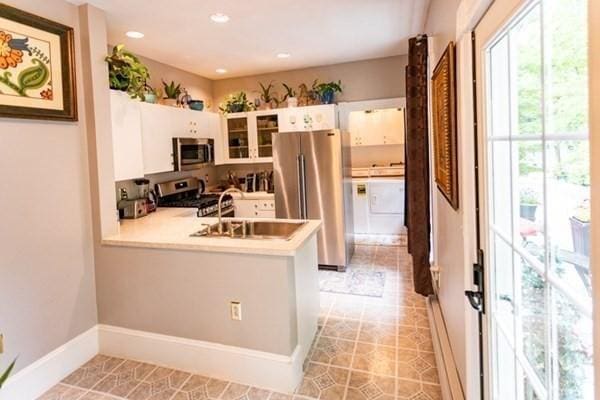 117 Church St Unit 4, North Attleboro, MA 02760 - kitchen with appliances with stainless steel finishes, a sink, light countertops, white cabinets, and a peninsula