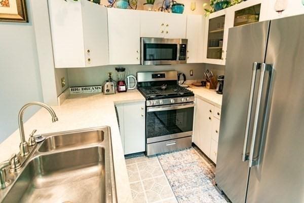 117 Church St Unit 4, North Attleboro, MA 02760 - kitchen featuring a sink, appliances with stainless steel finishes, white cabinets, and light countertops