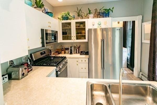 117 Church St Unit 4, North Attleboro, MA 02760 - kitchen featuring glass insert cabinets, light countertops, white cabinetry, a sink, and appliances with stainless steel finishes