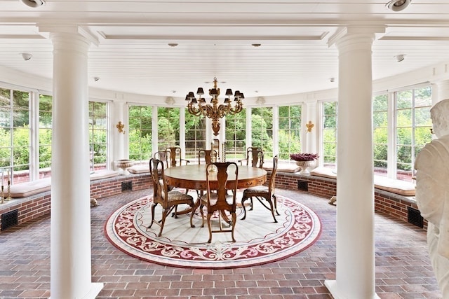 sunroom with ornate columns, an inviting chandelier, and a wealth of natural light