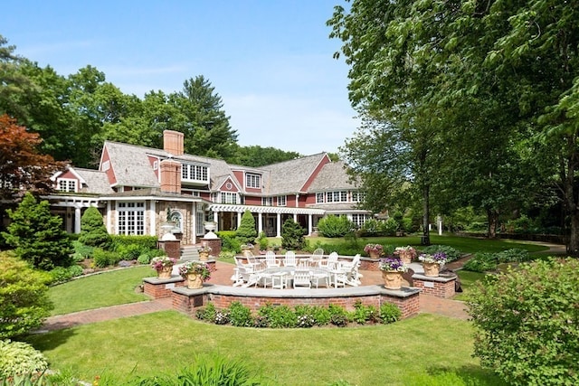 back of property featuring a lawn and a patio