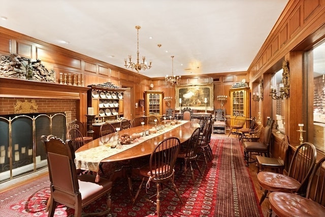 dining area with an inviting chandelier, a brick fireplace, and crown molding