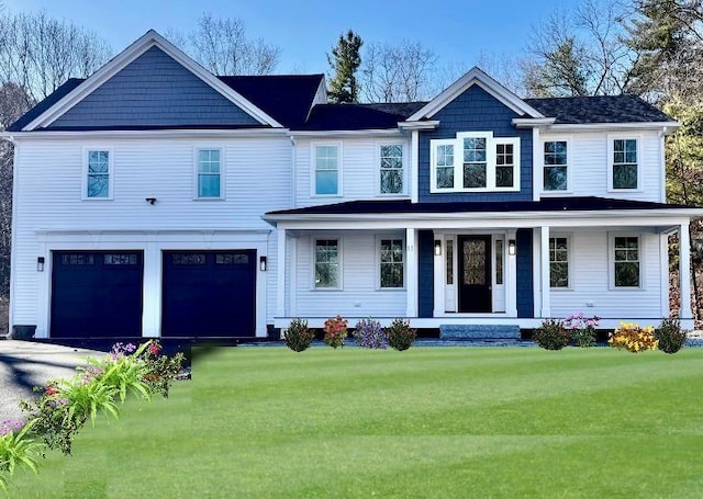 view of front of house featuring a front yard, a garage, and covered porch