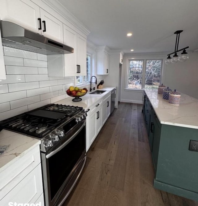 kitchen featuring appliances with stainless steel finishes, tasteful backsplash, sink, pendant lighting, and white cabinetry